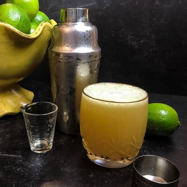 A glass cup on a table, with Margarita