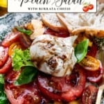 Sliced peaches and tomatoes with burrata cheese, fresh basil leaves, and a drizzle of balsamic glaze, arranged on a patterned plate alongside a slice of bread.