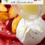 Slices of tomato and peach are arranged on a plate, topped with burrata cheese. Salad dressing is being poured over the ingredients. Overlaid text reads: "Fresh Peach and Tomato Caprese Salad with creamy burrata cheese.