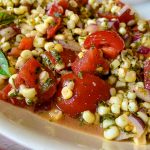 A plate of food, with Salad and Tomato.