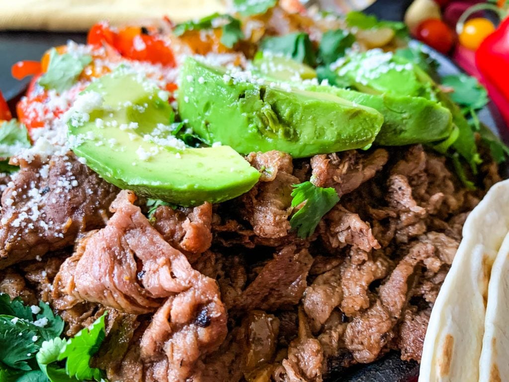 up close of beef and avocado in tender shaved beef fajitas