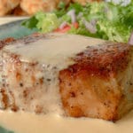 close up of a pork chop with sauce