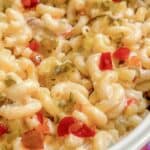 Macaroni salad in a bowl with a wooden spoon.