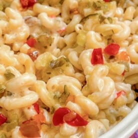 Macaroni salad in a bowl with a wooden spoon.