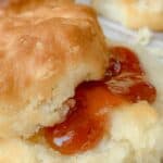 A buttered biscuit with strawberry jam.
