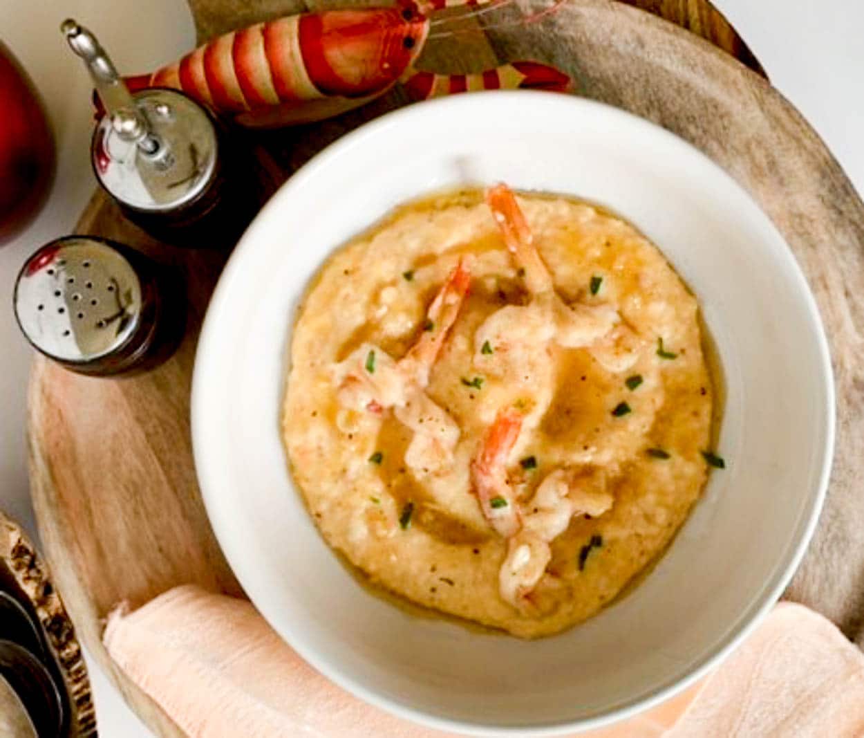 a white bowl with shrimp over grits