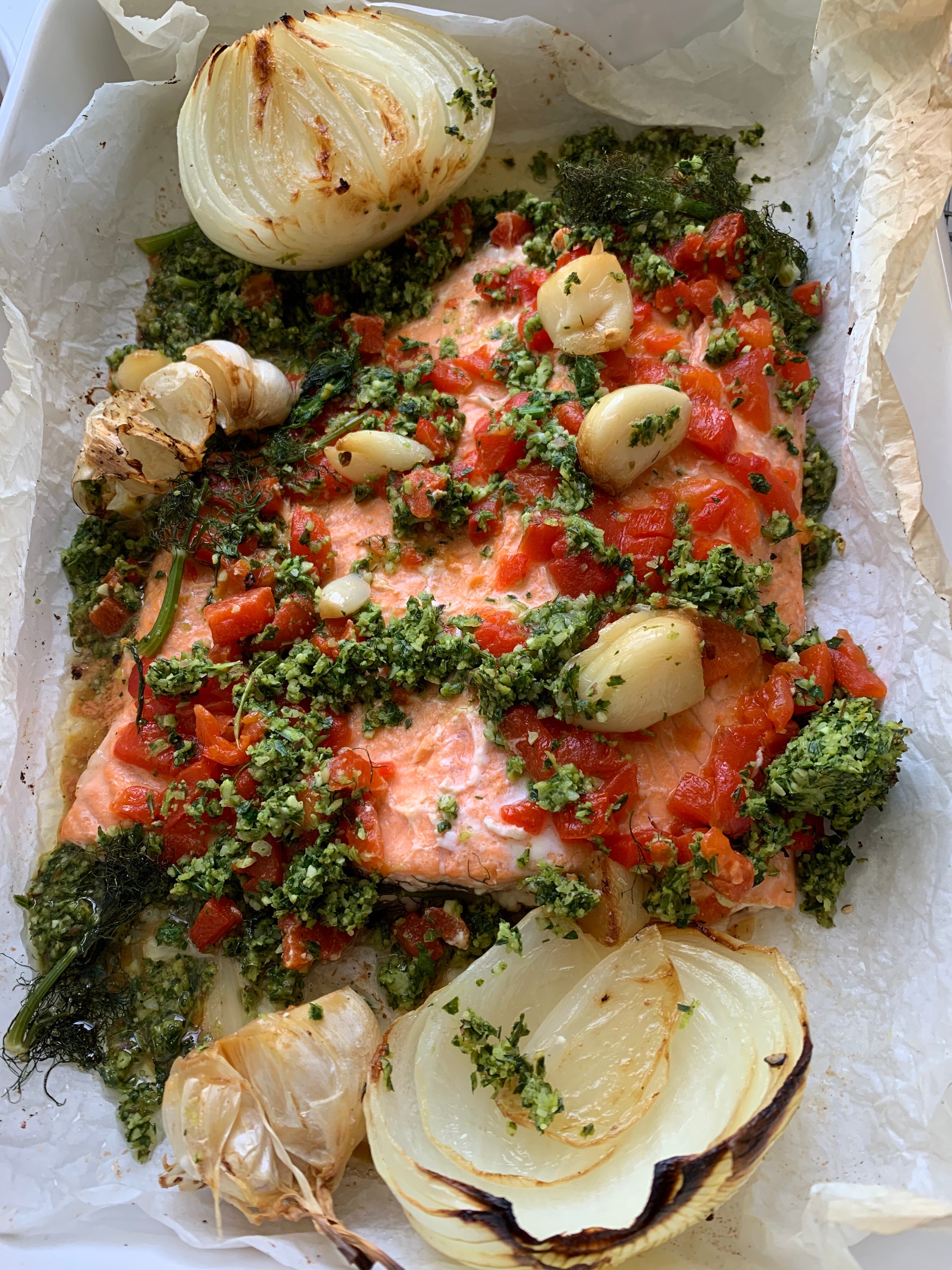 a white baking dish, with salmon fillet and vegetables