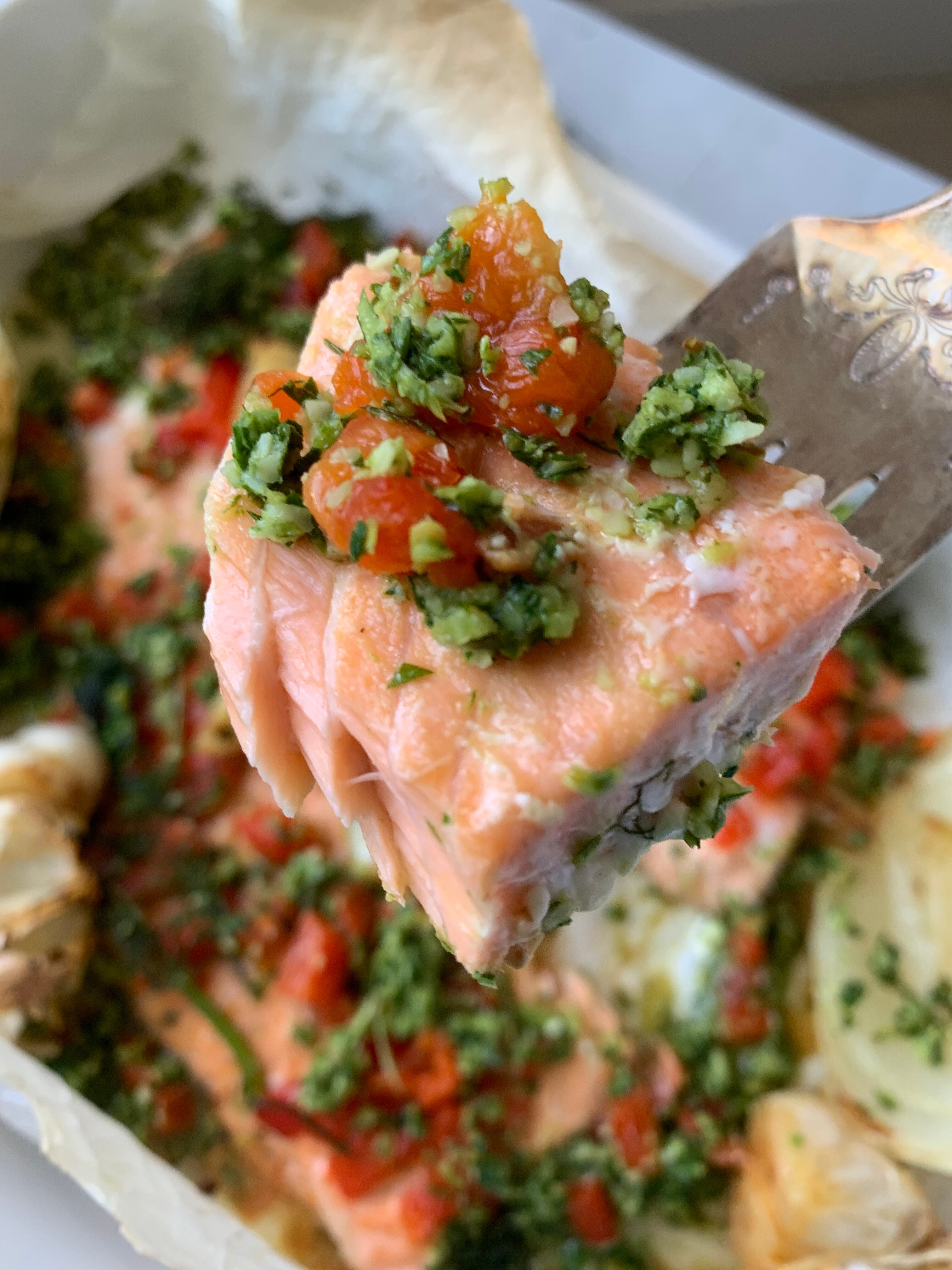 a white baking dish, with salmon fillet and vegetables