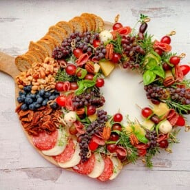 A Charcutier Board with meats and cheeses and fresh fruits.