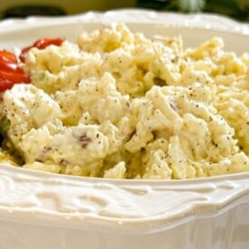 A big serving bowl filled with Amish potato salad.