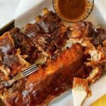 A plate of food with a fork and knife, with Barbecue and Ribs.
