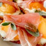 Fresh sage leaves piled onto a ricotta crostini with peaches and prosciutto.