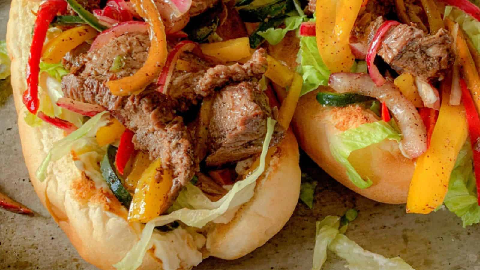 Hoagie rolls stuffed with steak and lettuce and peppers with a dressing.