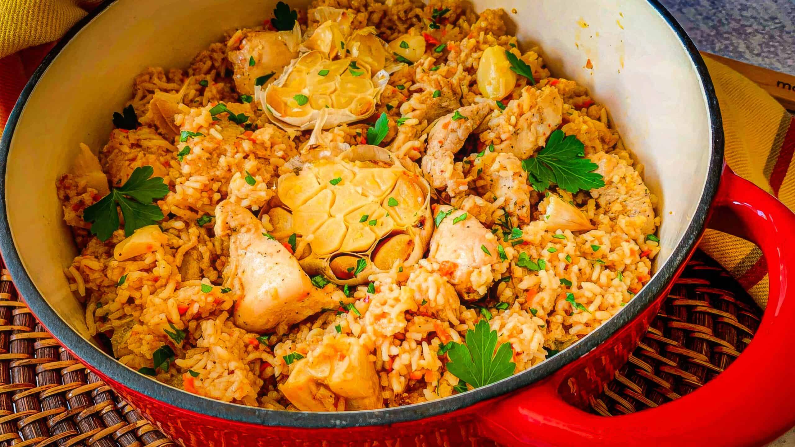 Chicken and rice with aromatics and garlic in a Dutch oven.