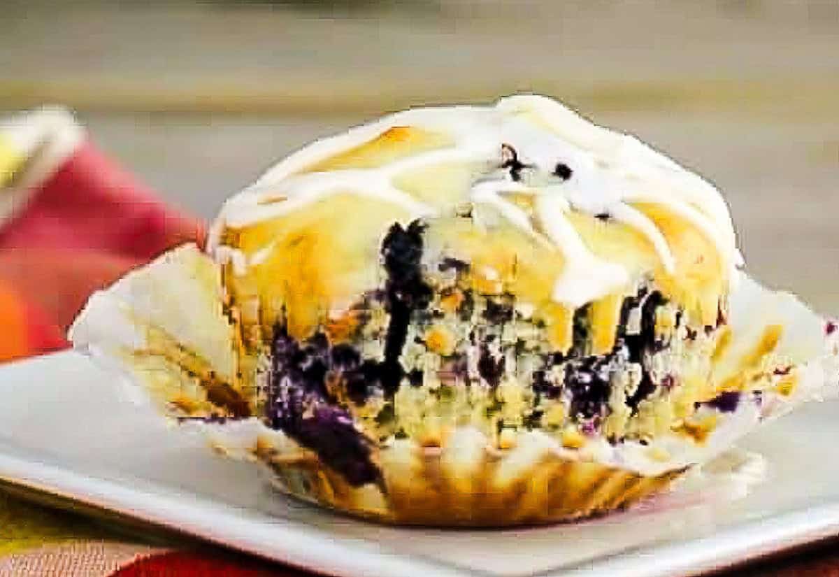 A blueberry muffin with white glaze.