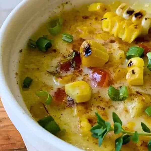 A crock of steamed corn pudding with herbs.