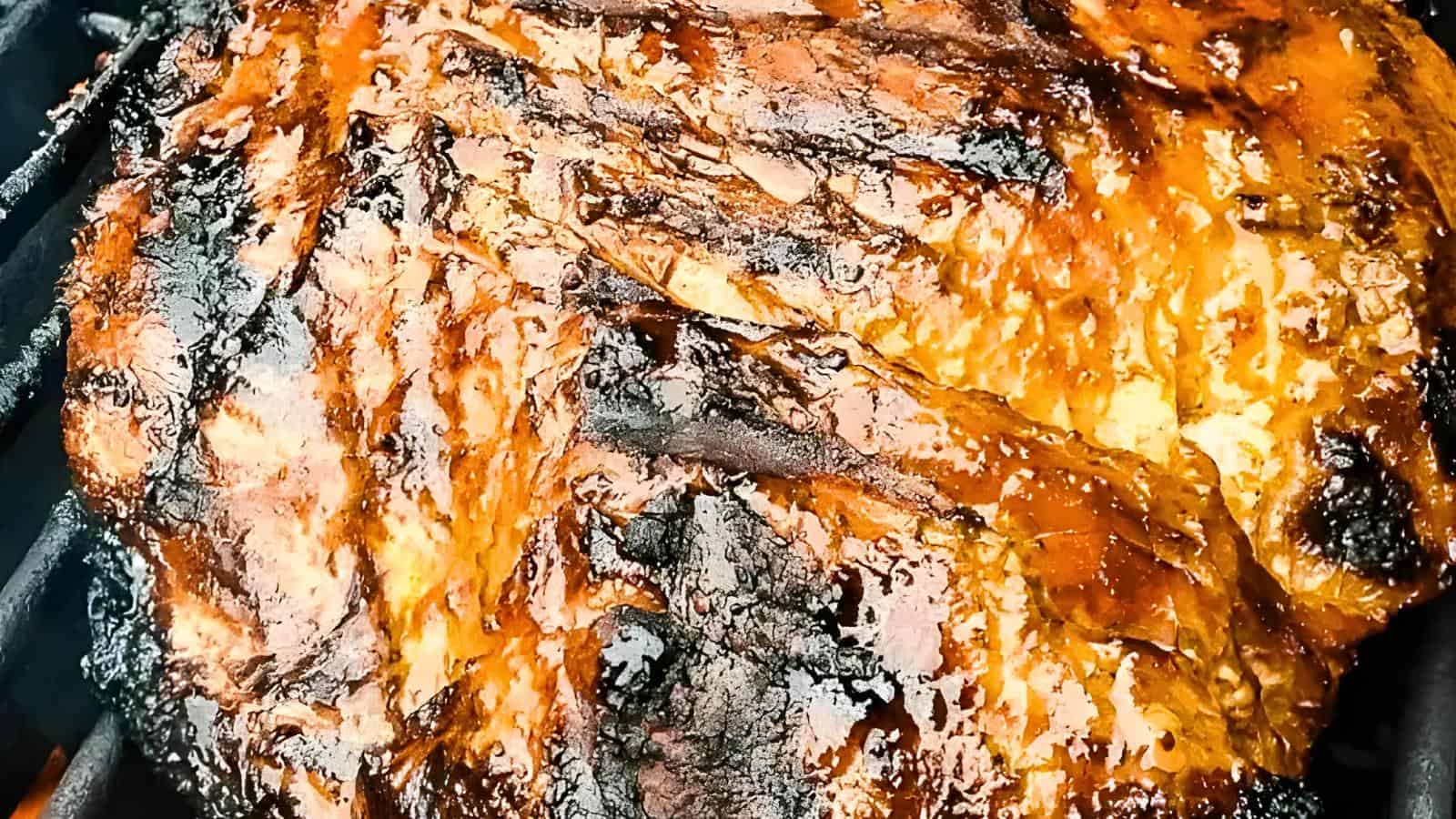 Grilled steak with char marks and glistening glaze.
