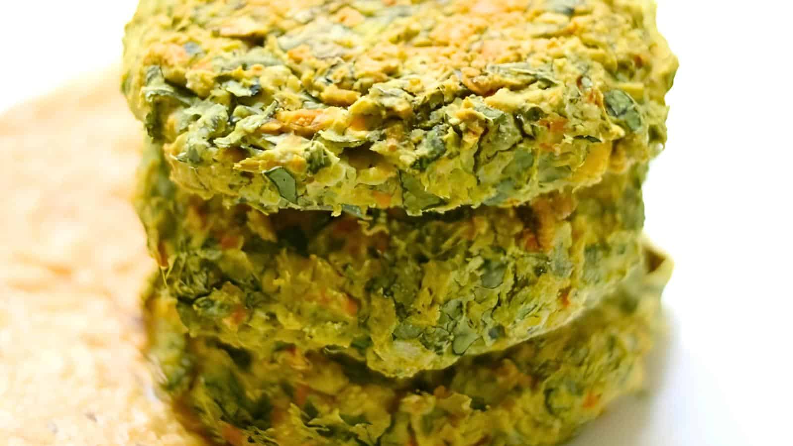 Three stacked green vegetable patties with a chunky texture and visible green and orange flecks.