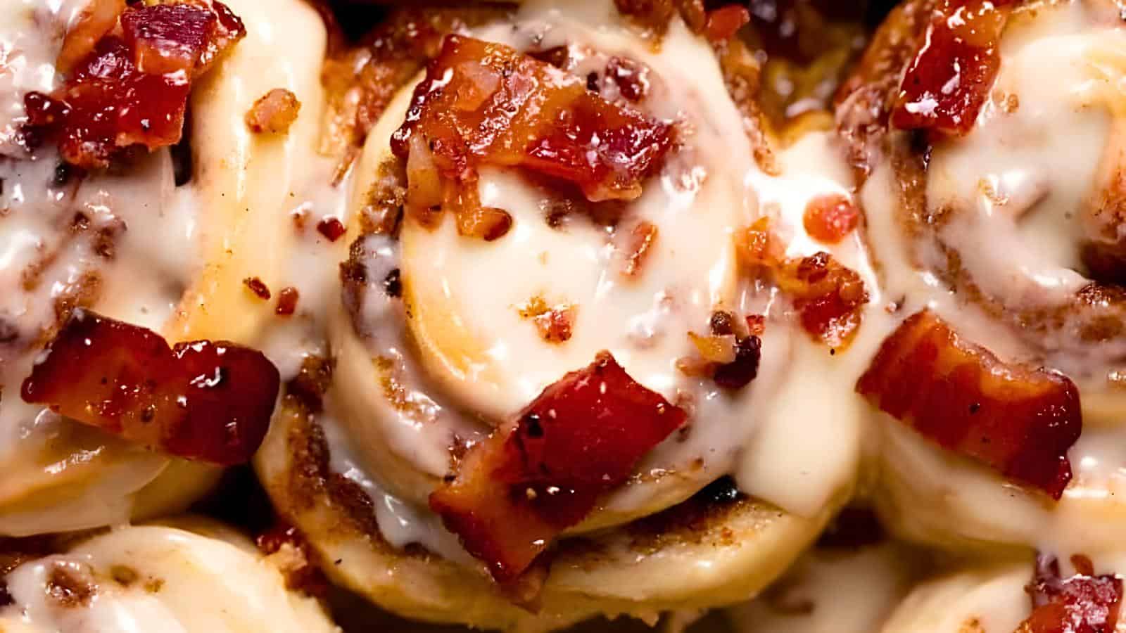 Cinnamon rolls with creamy icing and crispy bacon pieces.