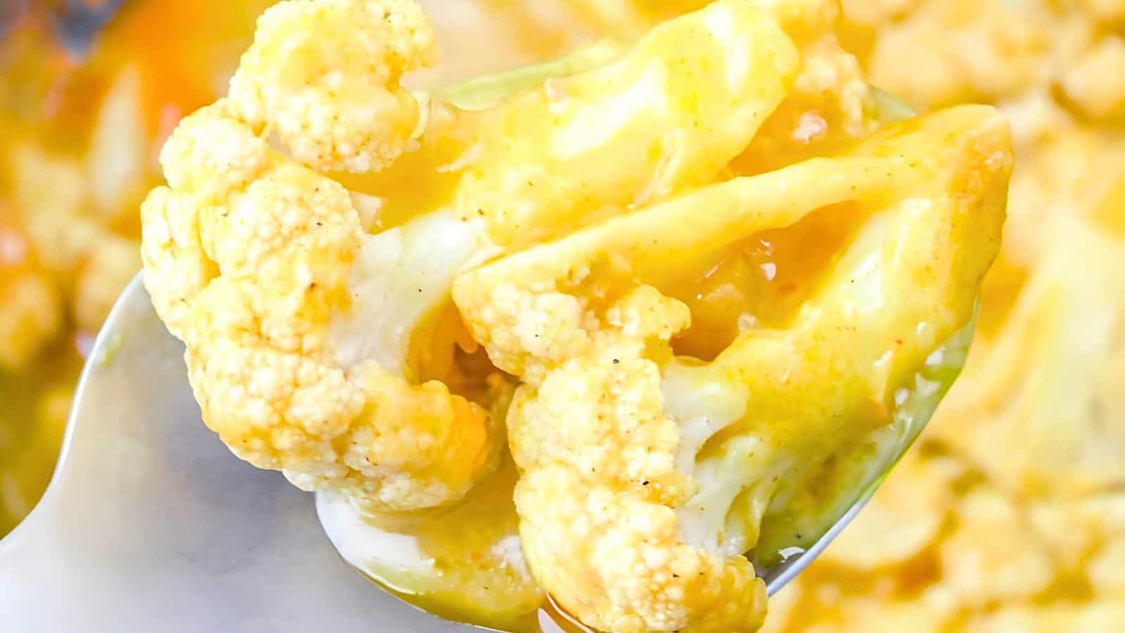 A spoonful of cauliflower with melted cheese and seasoning.