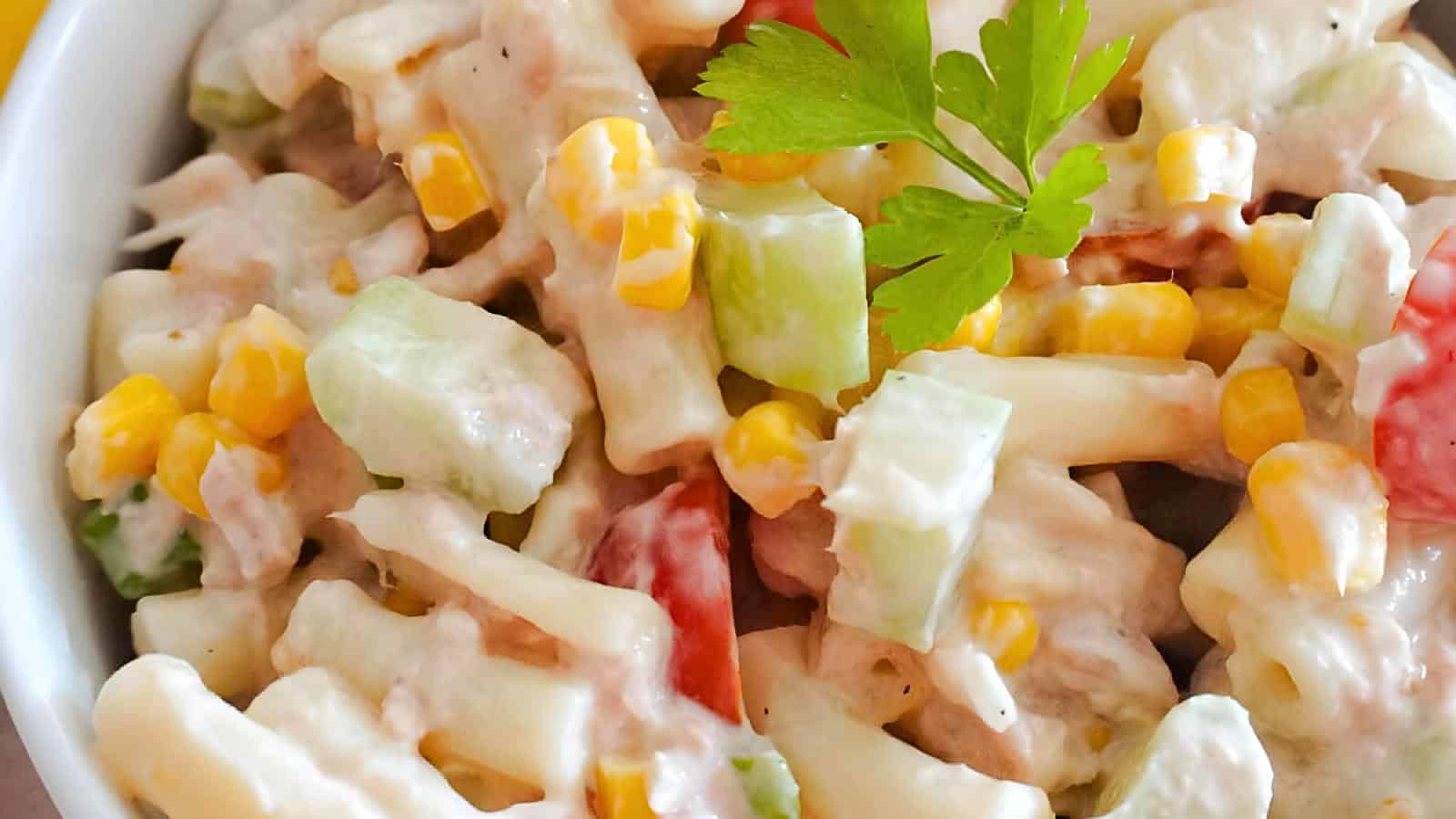 A portion of pasta sweetcorn salad in a white bowl. 