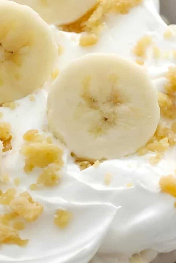 Whipped cream topped with banana slices and crumbled toppings.