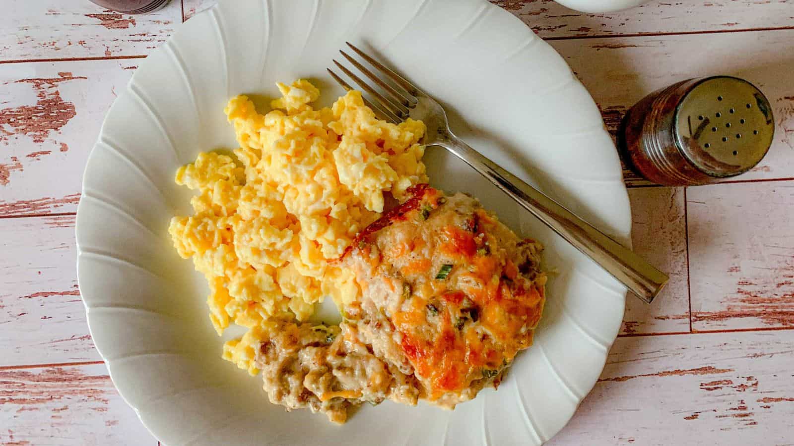 A plate filled with scrambled eggs and breakfast casserole with Bob Evans sausage.