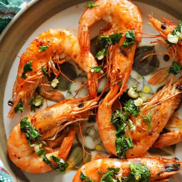 6 grilled shrimp on a plate.