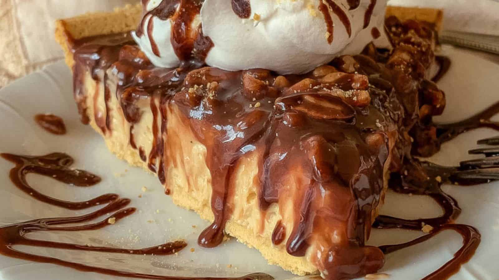 peanut butter and chocolate cream pie on plate with whipped cream.