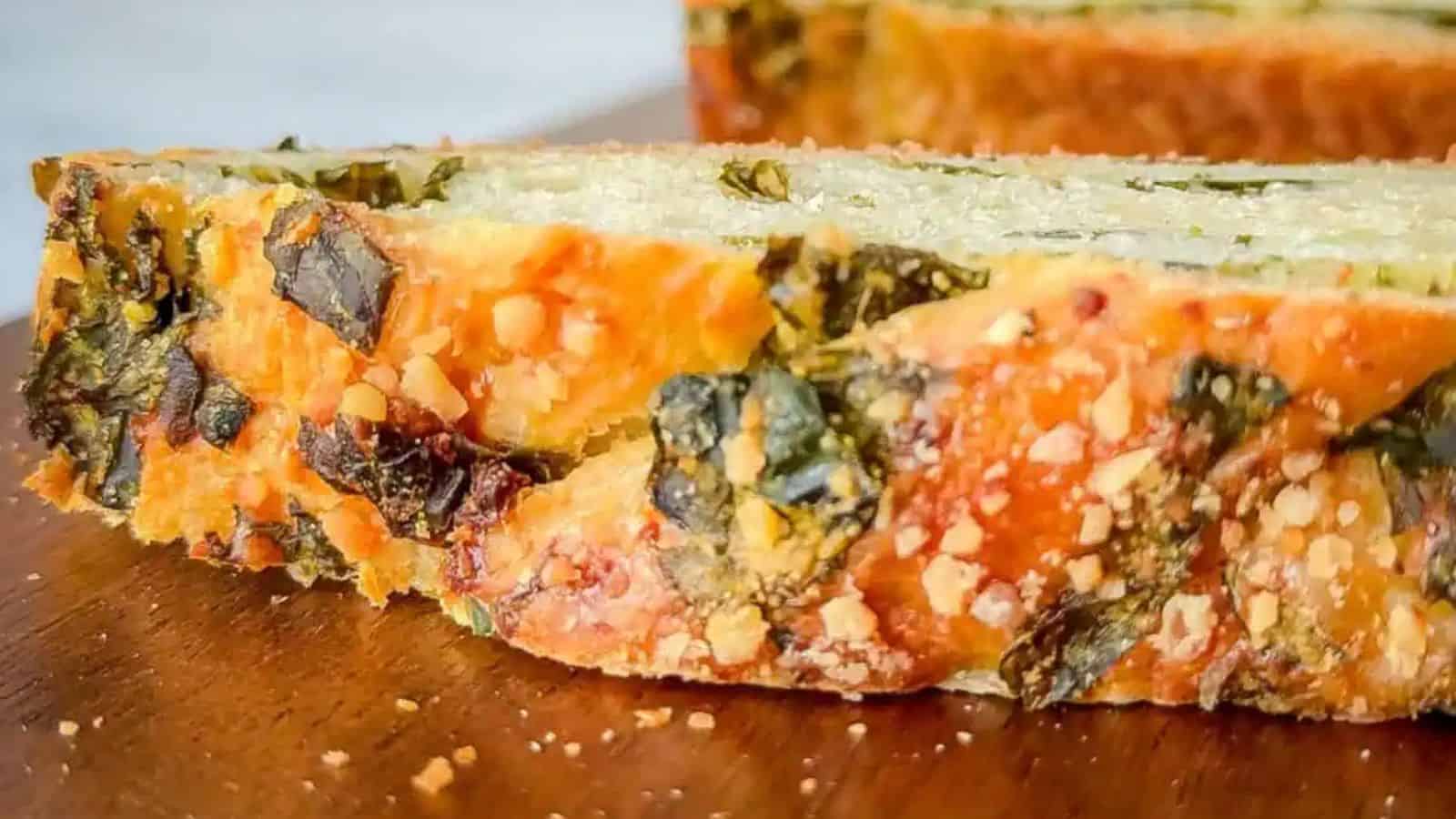 A sideways slice of bread with herby green bits and cheese.