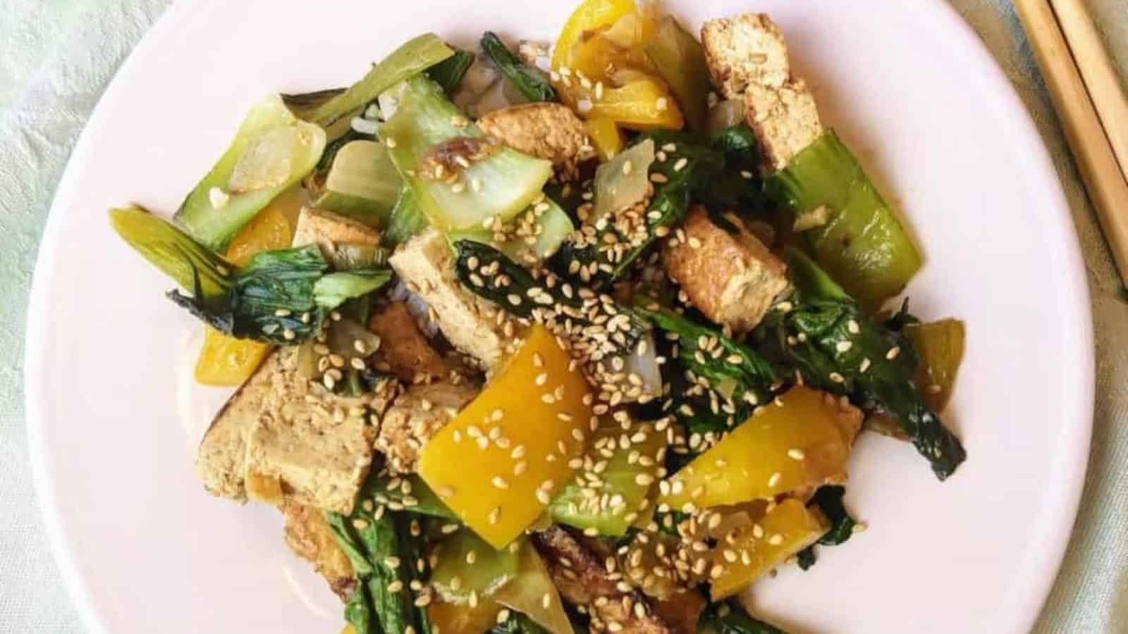 tofu pieces, yellow peppers, and baby bok choy with sesame seeds.
