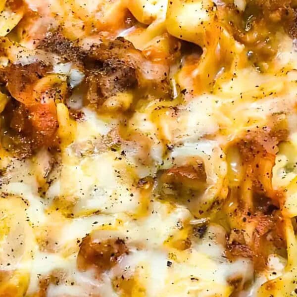 A baked pasta casserole with melted cheese, ground meat, and seasonings.