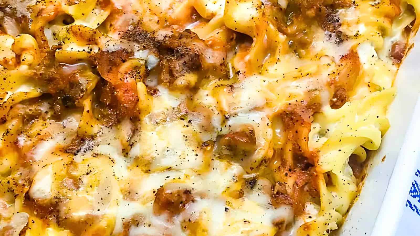 A baked pasta casserole with melted cheese, ground meat, and seasonings.