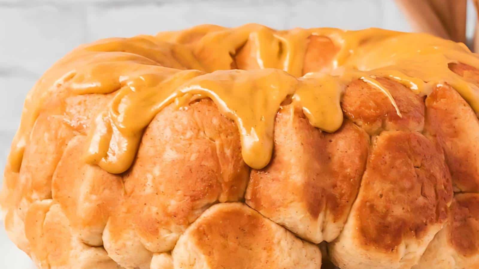A bundt-shaped monkey bread with a thick drizzle of caramel glaze.