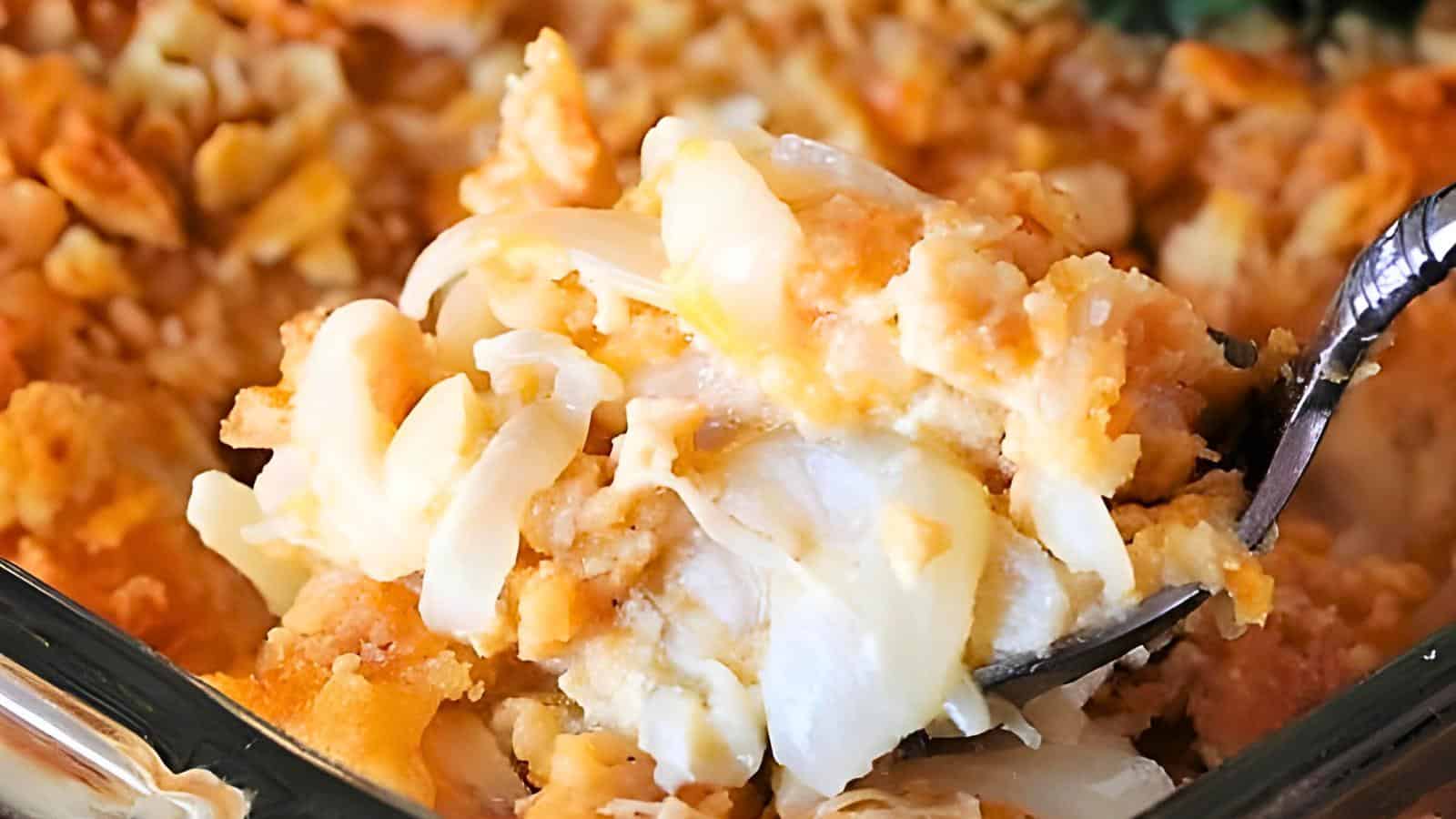 A spoonful of cheesy onion casserole with a golden-brown topping and creamy, melted cheese.