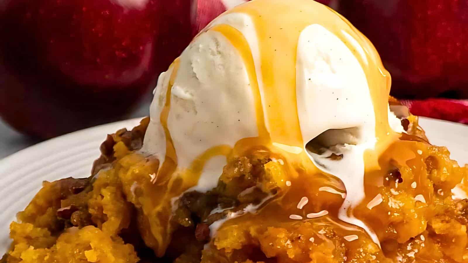 A scoop of vanilla ice cream topped with caramel sauce, sitting on a bed of apple crumble.