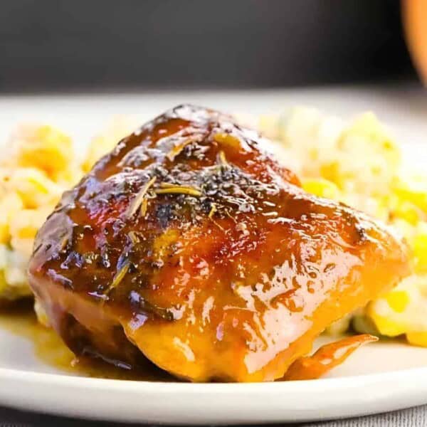 A plate with glazed salmon and a creamy corn and vegetable side dish.
