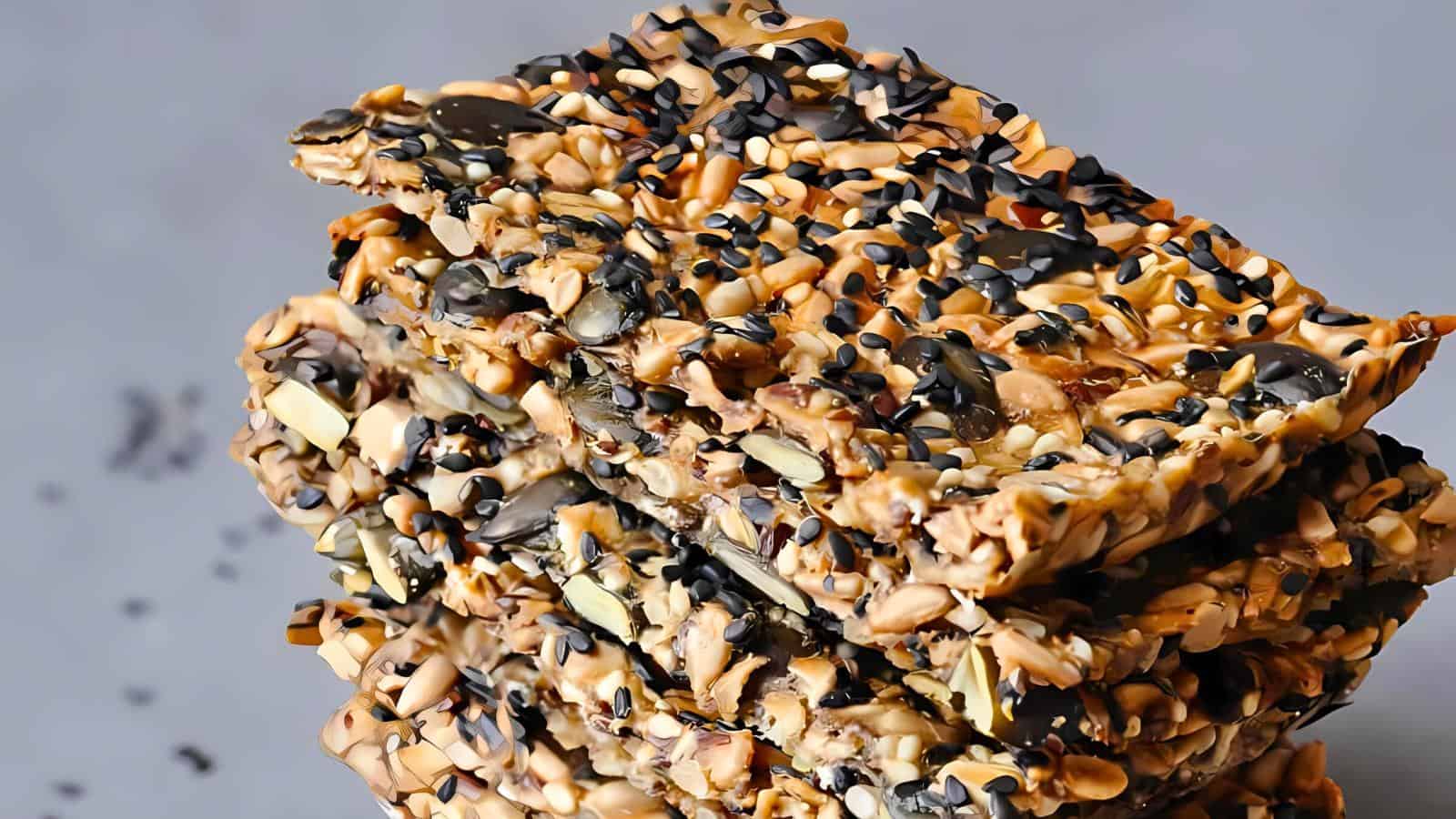Close-up of a stack of three bars featuring a mixture of various seeds and nuts tightly packed together.