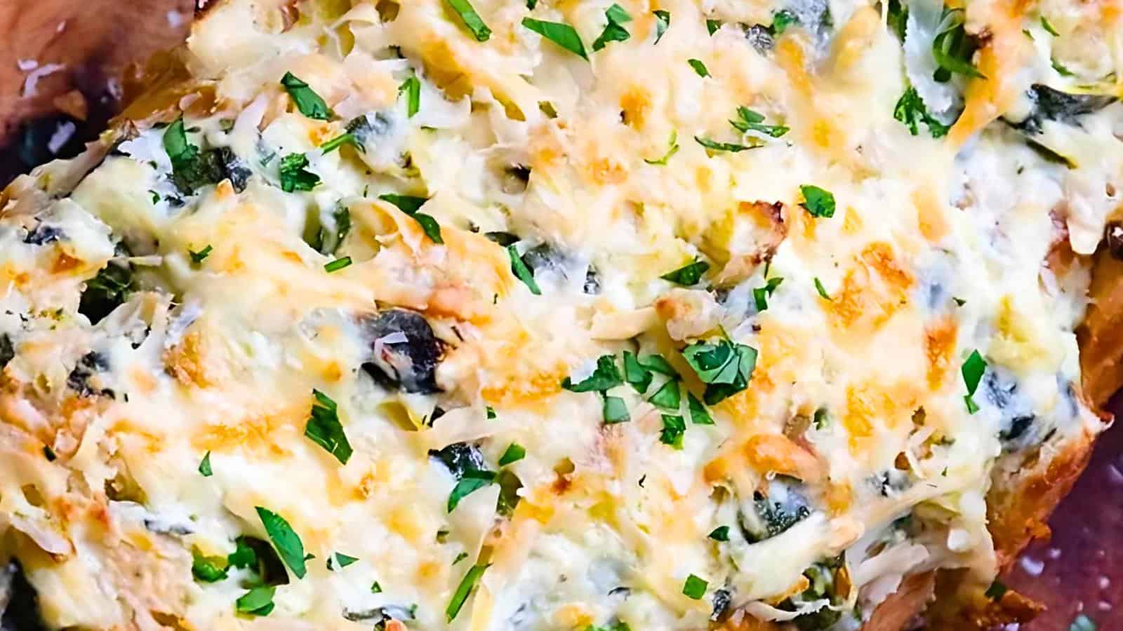 Close-up of a baked dish topped with melted cheese, herbs, and chopped greens, showcasing a crispy, golden-brown texture and garnished with fresh parsley.
