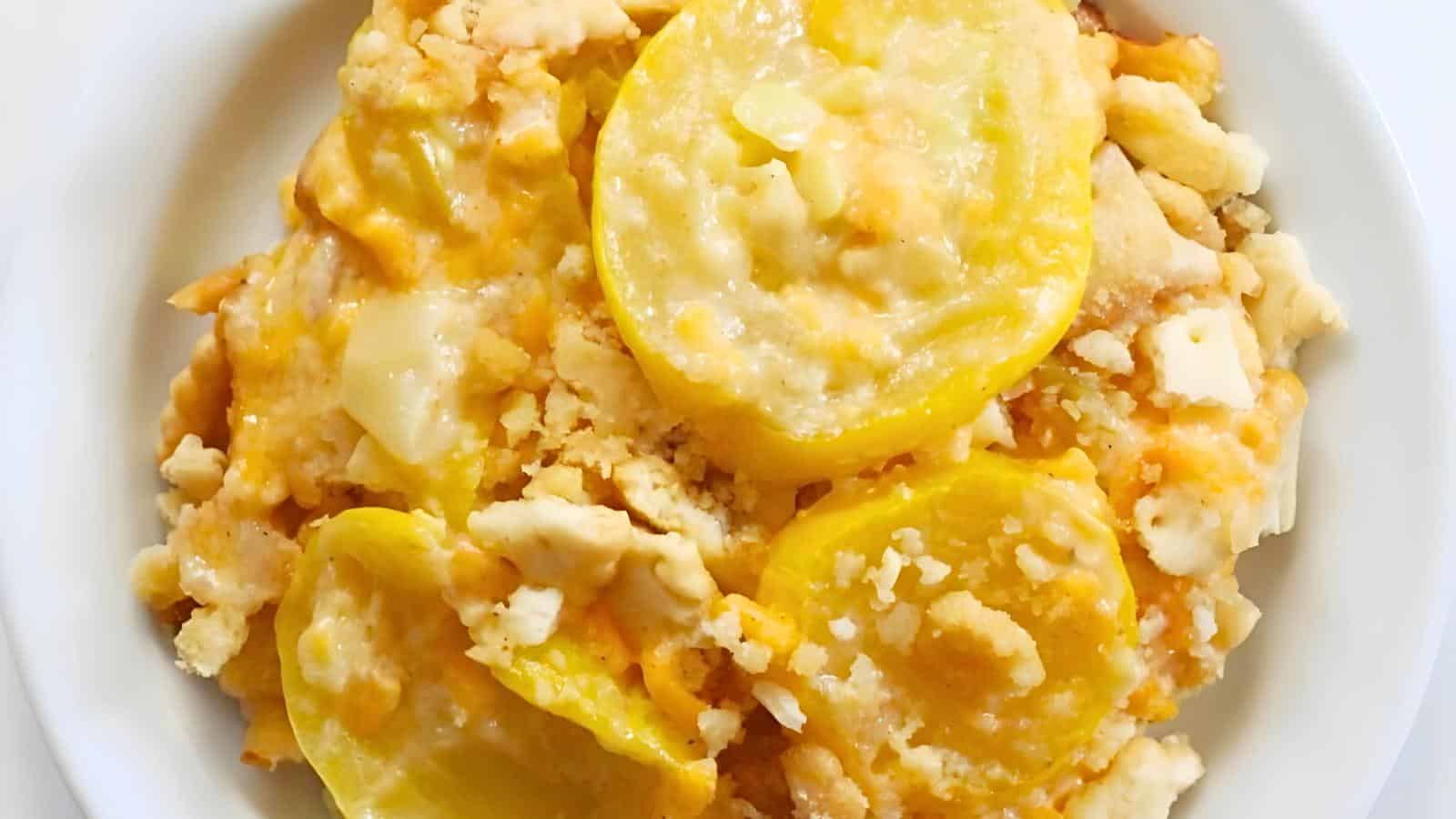 A bowl of yellow squash casserole with a crumbly cheese topping.