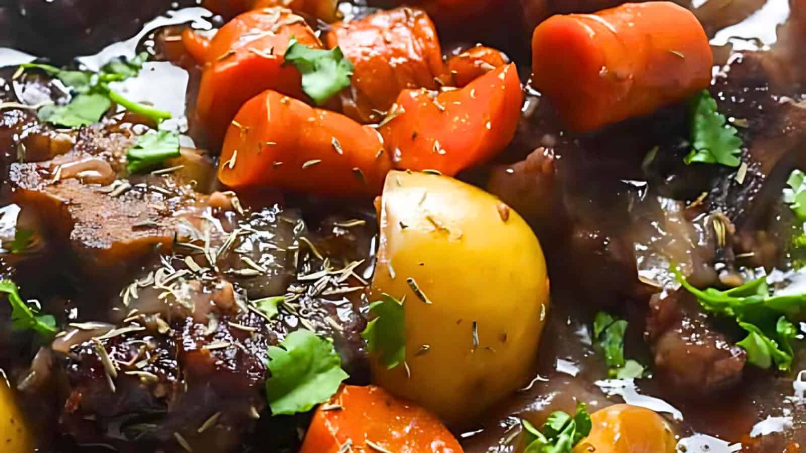 Cooked carrots, potatoes, and meat garnished with fresh herbs and spices in a rich sauce.