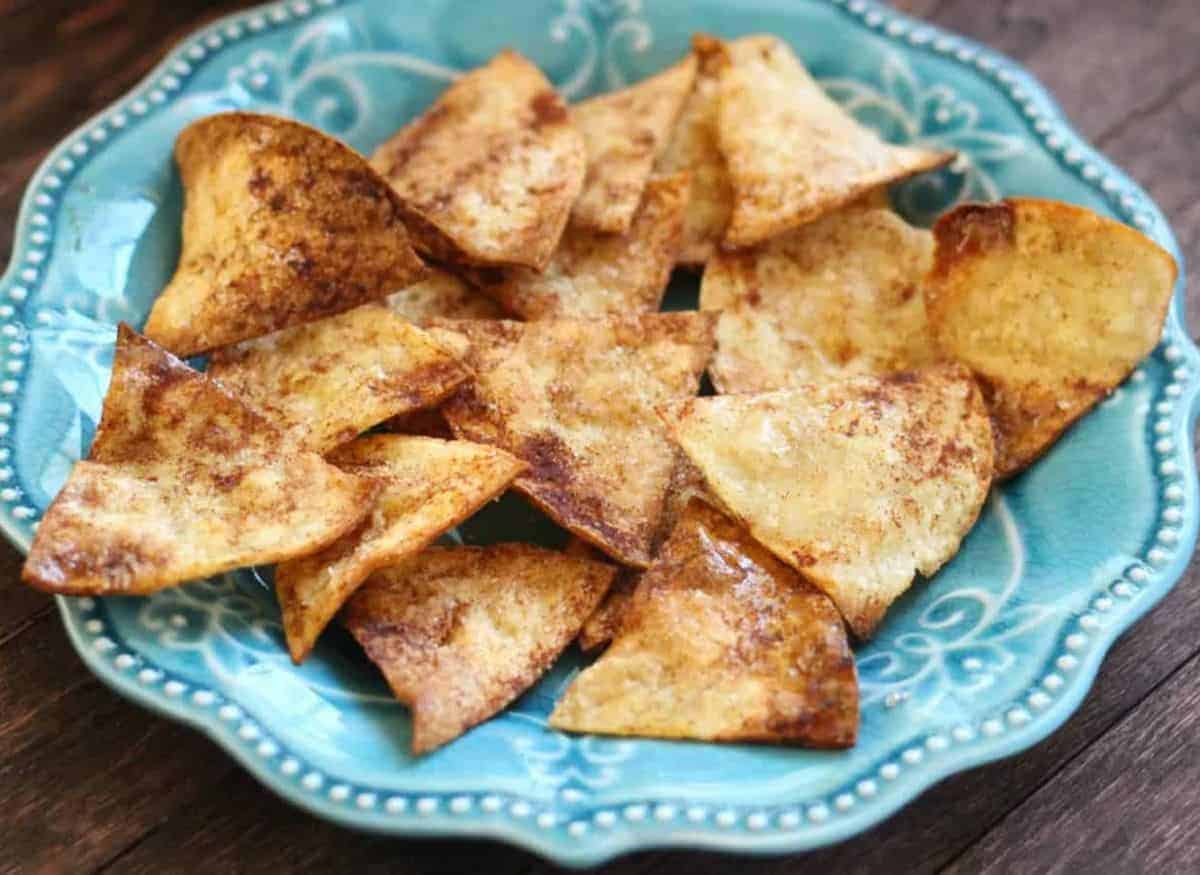 Cinnamon chips on a blue green plate on a wooden background.
