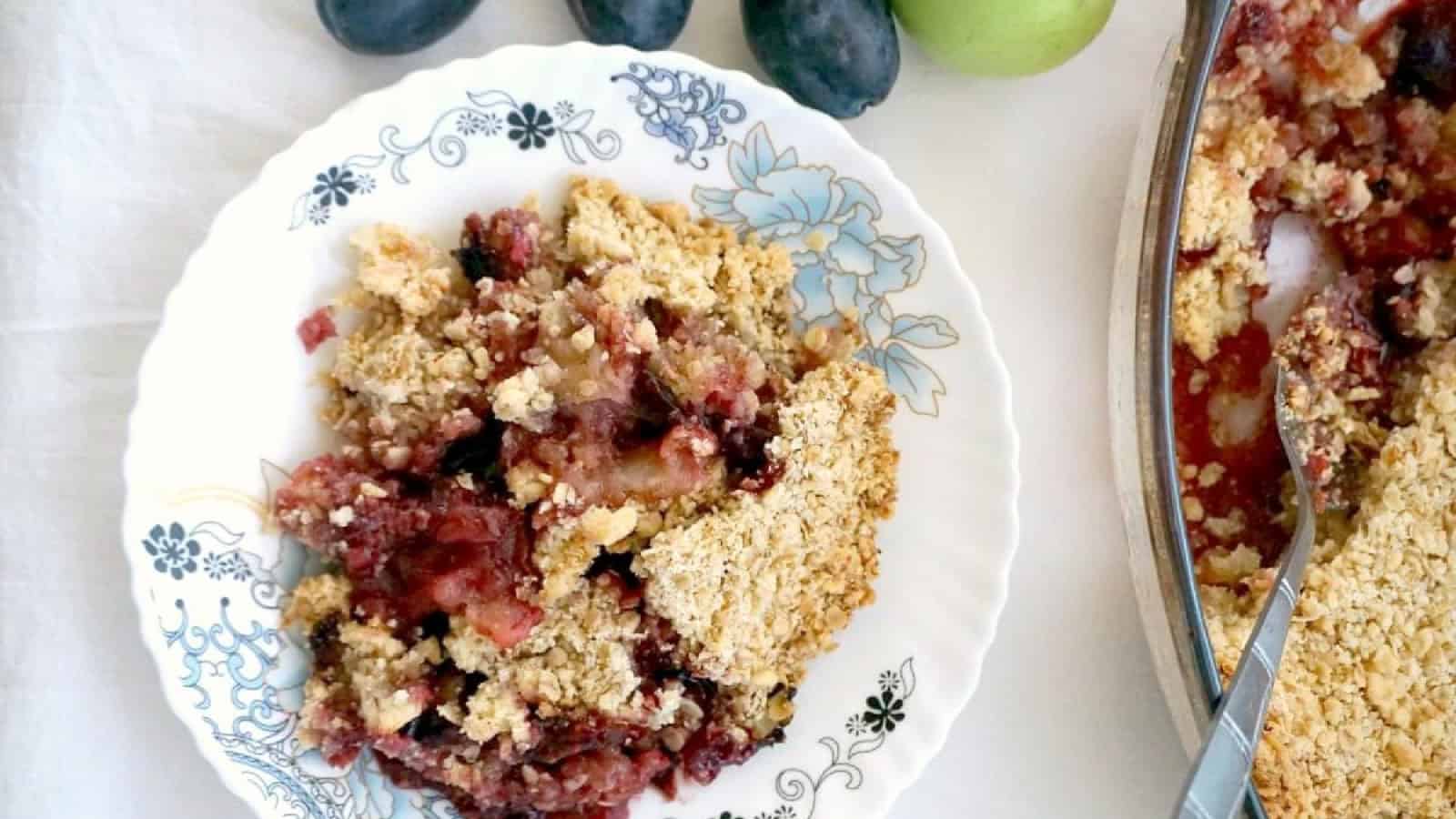 A plate with apple and plum crumble.