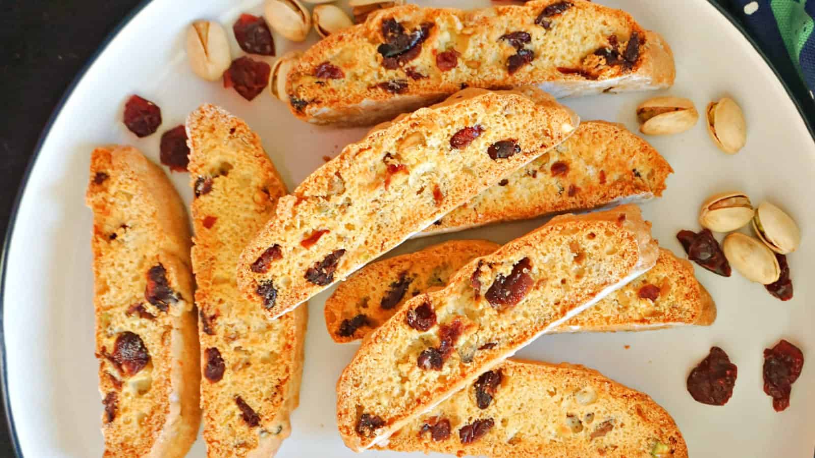 Biscotti with cranberries and pistachios on a white plate.