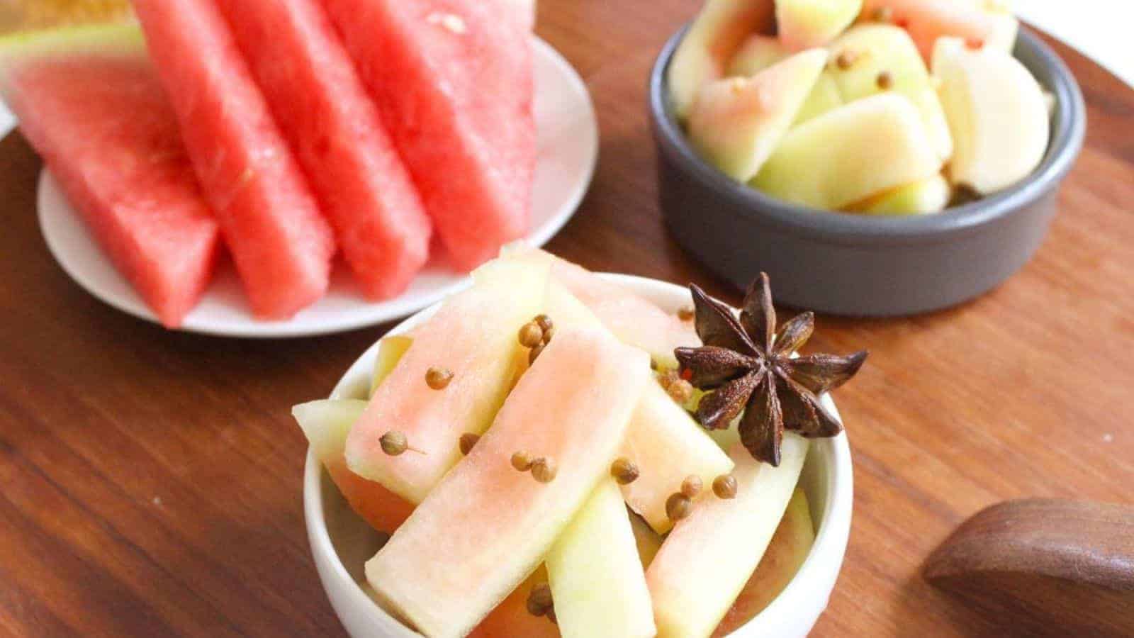 A small bowl with watermelon rind pickles and star anise on top.