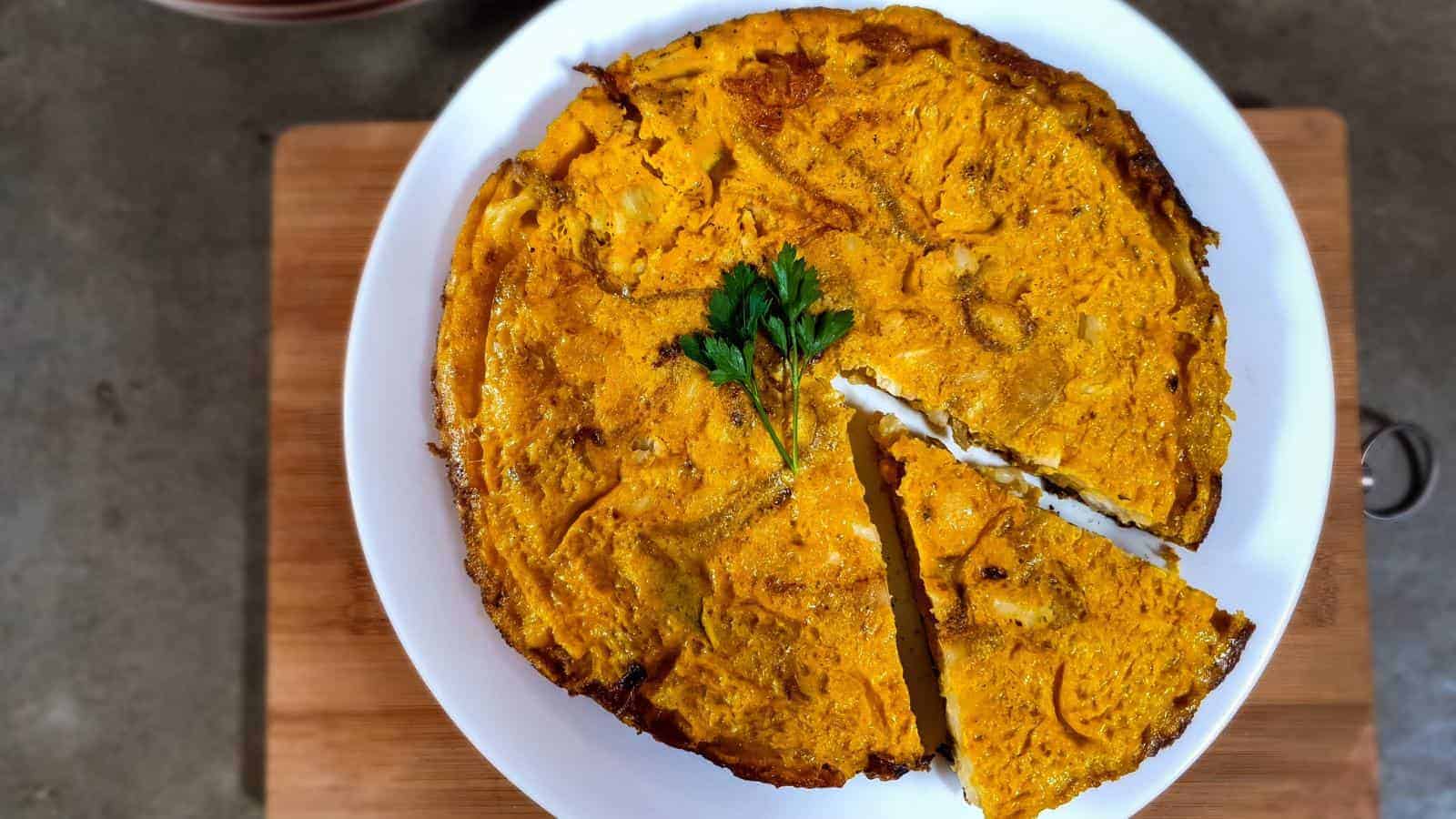 A picture of Spanish Omelette with Cauliflower and fresh parsley leaf.