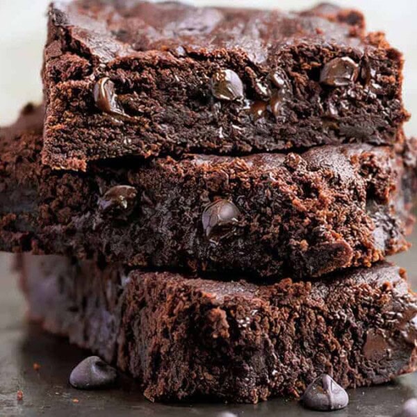 A stack of three double chocolate chip bars with melted chocolate chip cookies dotted throughout.
