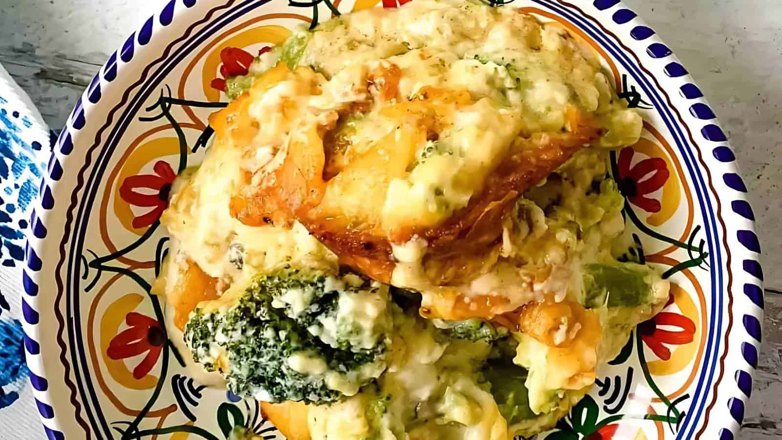 A colorful dish with vibrant patterns contains a serving of broccoli cheddar casserole. The casserole appears creamy, with melted cheese enveloping broccoli florets and chunks of bread, all served on a decorative bowl.