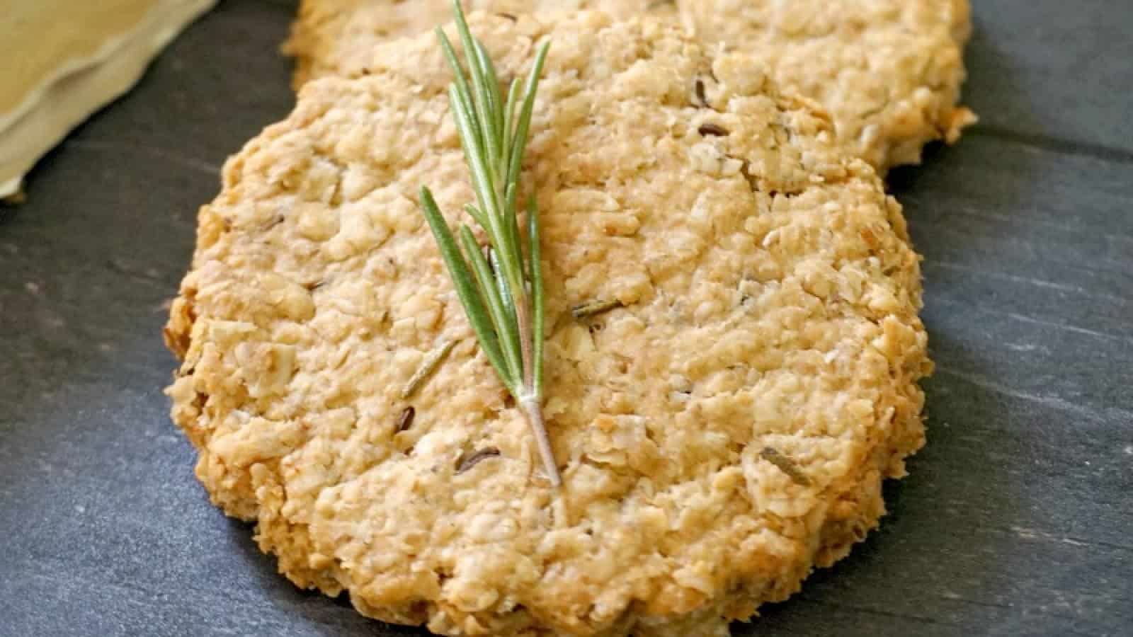 2 oatmeal cookies with a small sprig of rosemary on top.