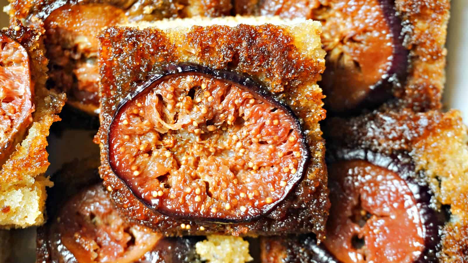 A fig upside down cake on top of other cake bars. 